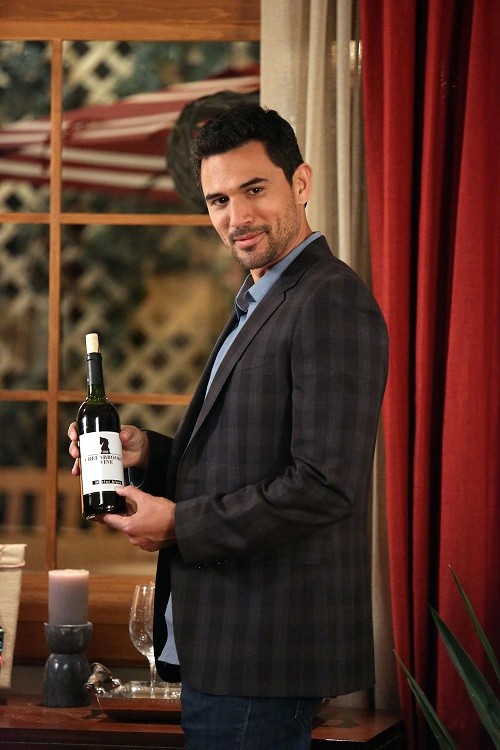Tony Bishara (Dominic Adams) avec une bouteille de vin à la main